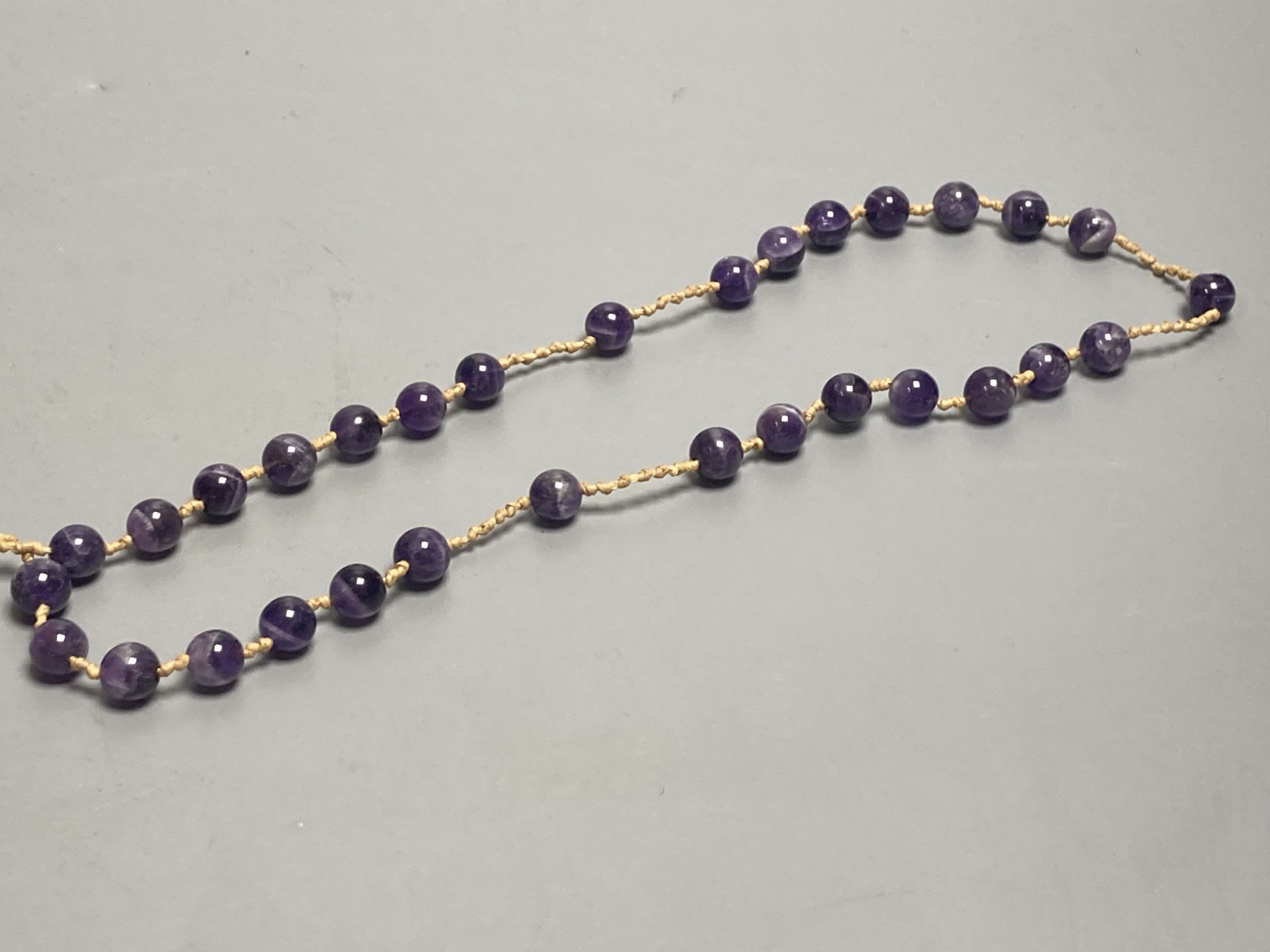 An amethyst bead necklace with amethyst pebble pendant.